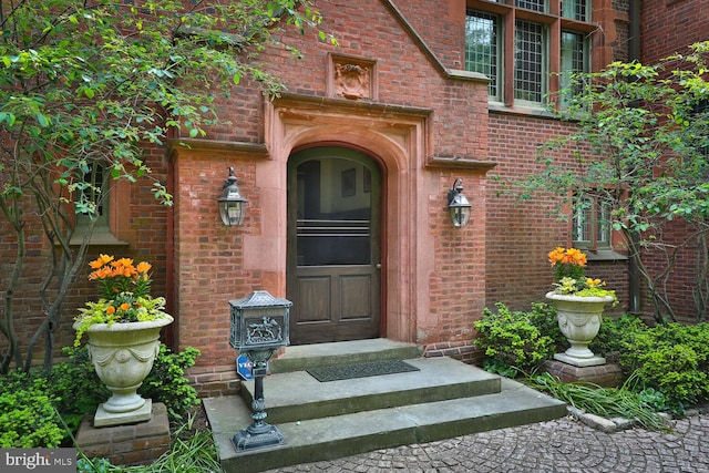 view of exterior entry featuring brick siding