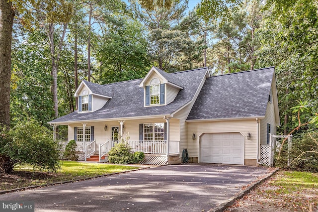 cape cod-style house featuring a garage and covered porch