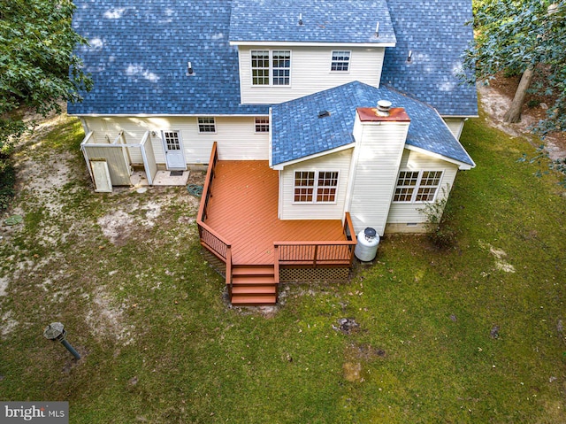 rear view of property featuring a yard and a deck