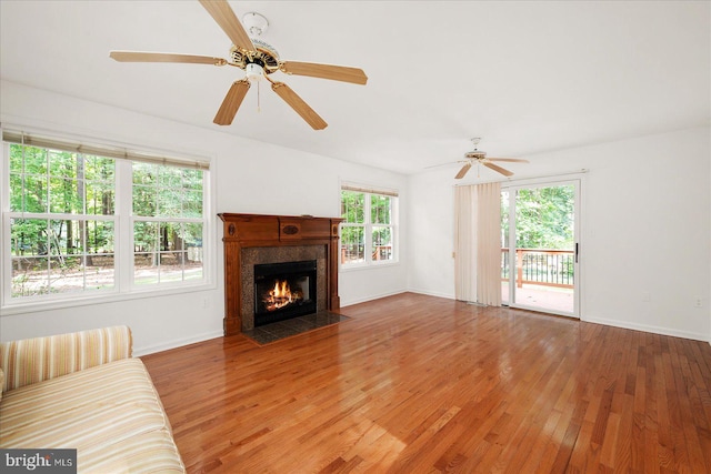 living room with ceiling fan, wood-type flooring, and a healthy amount of sunlight