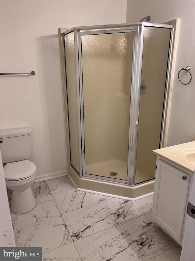 bathroom featuring vanity, baseboards, a stall shower, toilet, and marble finish floor