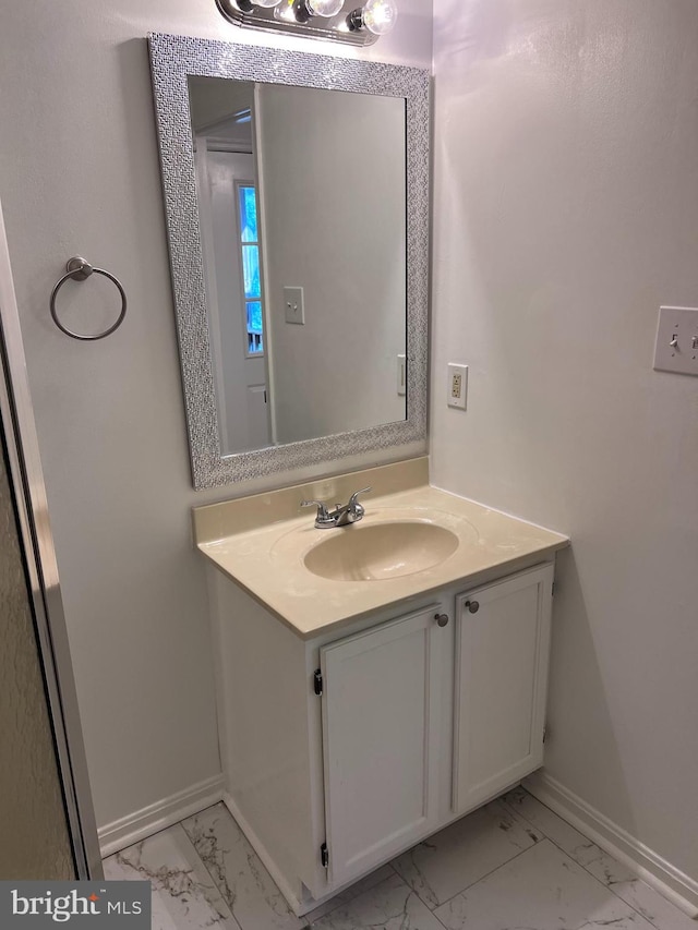 bathroom with baseboards, marble finish floor, and vanity