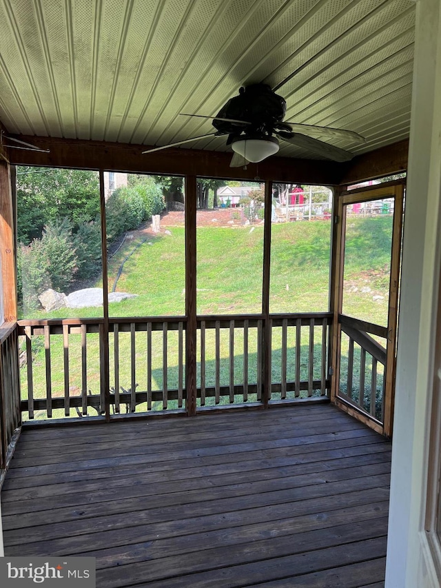 wooden deck featuring a lawn and ceiling fan