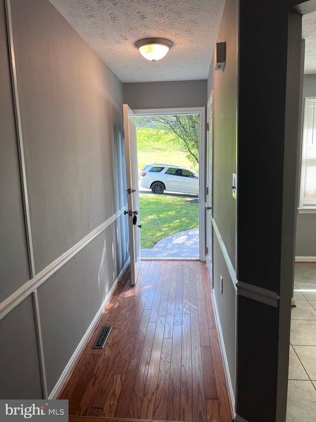 entryway with a textured ceiling and hardwood / wood-style flooring