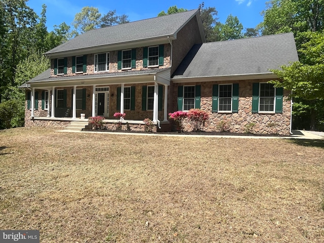 colonial house with a front yard and covered porch