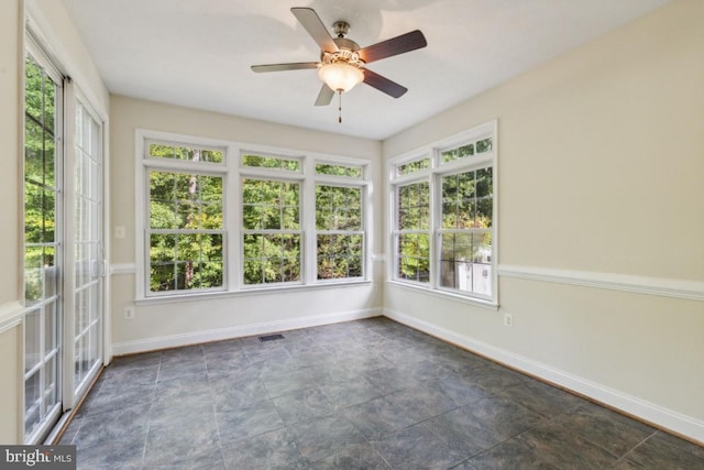 unfurnished sunroom featuring ceiling fan