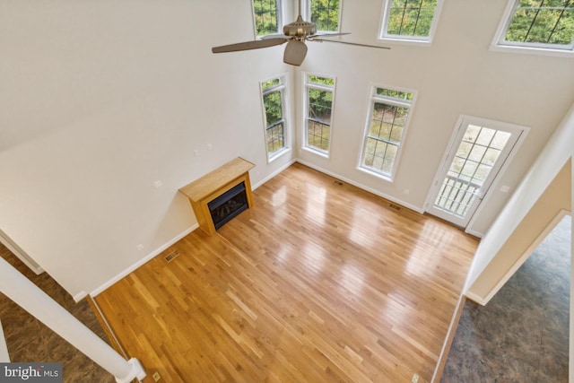 unfurnished living room featuring hardwood / wood-style floors, ceiling fan, and plenty of natural light