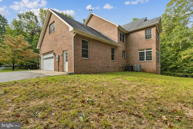 view of home's exterior featuring cooling unit, a yard, and a garage