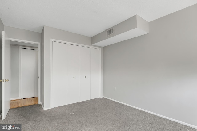 unfurnished bedroom with a closet and carpet floors