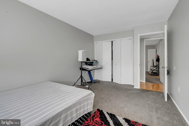 carpeted bedroom featuring a textured ceiling and a closet