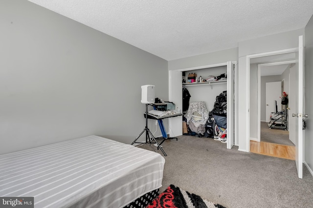 carpeted bedroom featuring a textured ceiling and a closet