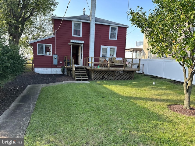 rear view of property with a yard and a deck