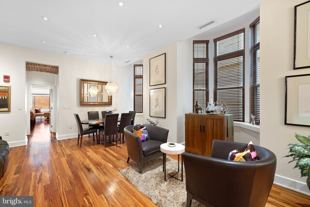 living room with a notable chandelier and light hardwood / wood-style floors