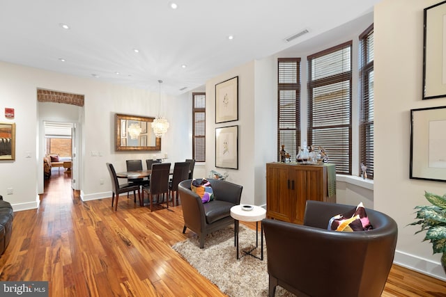 sitting room with recessed lighting, visible vents, baseboards, and wood finished floors