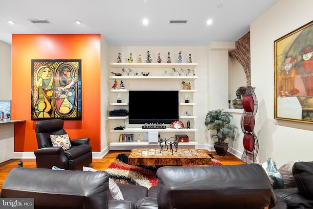 living room with visible vents, recessed lighting, baseboards, and wood finished floors