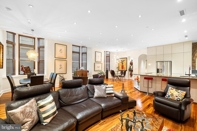 living room with light hardwood / wood-style flooring and sink