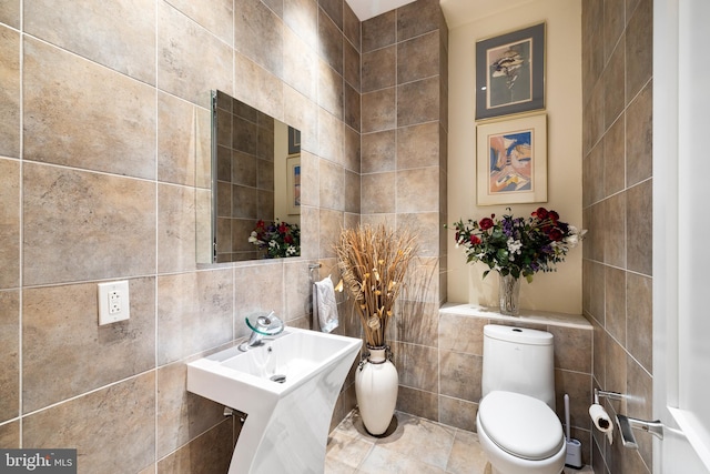 bathroom featuring tile walls and toilet