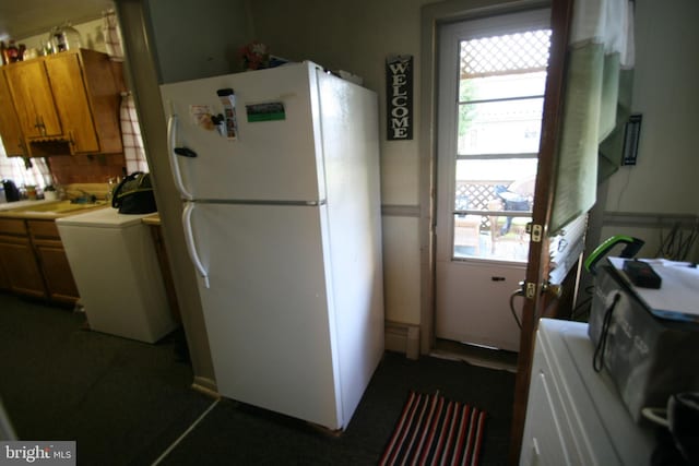361 Ridgley, Orbisonia, PA 17243 - kitchen featuring brown cabinetry, washer / clothes dryer, a sink, backsplash, and freestanding refrigerator