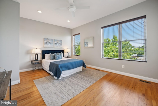 bedroom with multiple windows, ceiling fan, and light hardwood / wood-style flooring