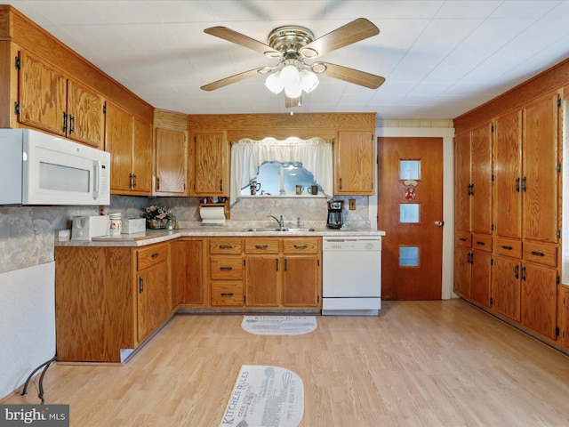 kitchen with light wood-type flooring, sink, white appliances, and tasteful backsplash