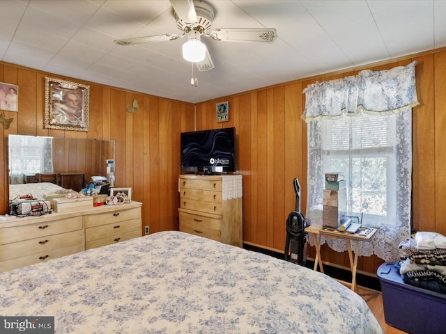 bedroom featuring wood walls and ceiling fan