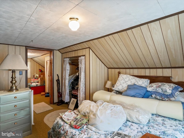 bedroom with wood walls, vaulted ceiling, and light colored carpet