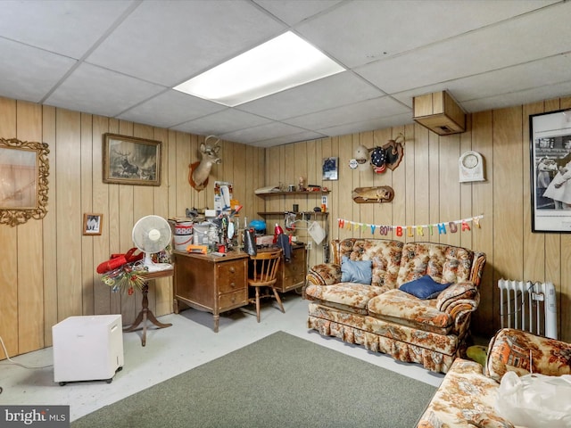 office space featuring wood walls, radiator heating unit, and a drop ceiling