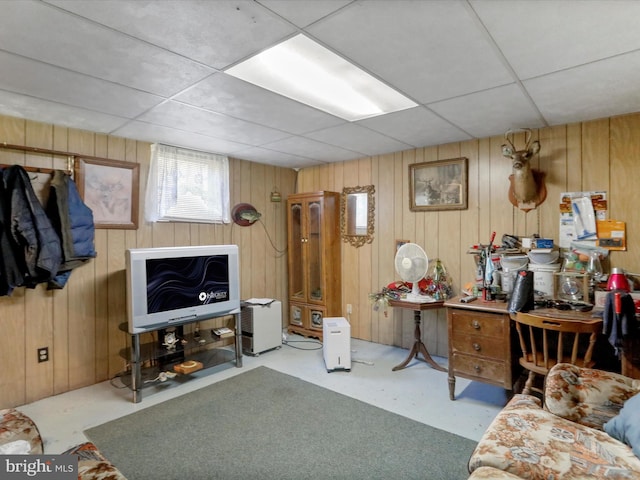 living room featuring wood walls and a paneled ceiling