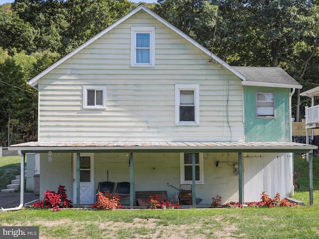 back of property with a yard and covered porch