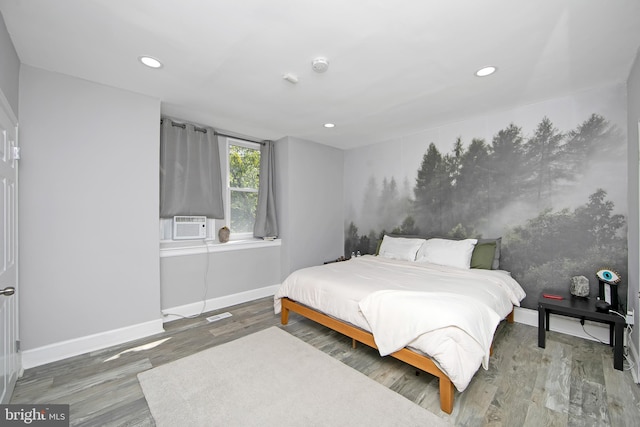 bedroom with cooling unit and hardwood / wood-style flooring