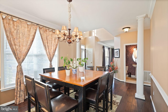 dining space with dark hardwood / wood-style flooring, decorative columns, ornamental molding, and a healthy amount of sunlight