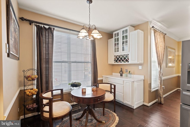 dining room featuring dark hardwood / wood-style flooring, a notable chandelier, and crown molding