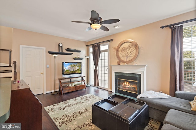 living room with dark wood-type flooring and ceiling fan