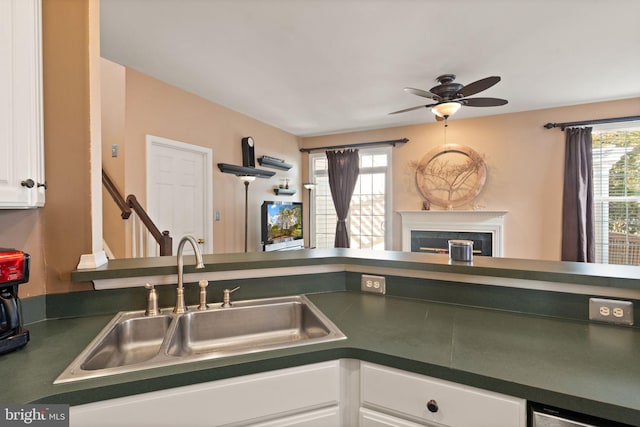 kitchen with a wealth of natural light, ceiling fan, white cabinetry, and sink