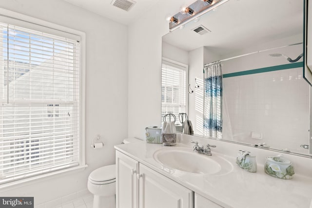 bathroom featuring plenty of natural light, vanity, toilet, and tile patterned flooring