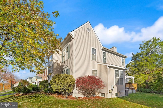 view of side of home with a lawn and a deck