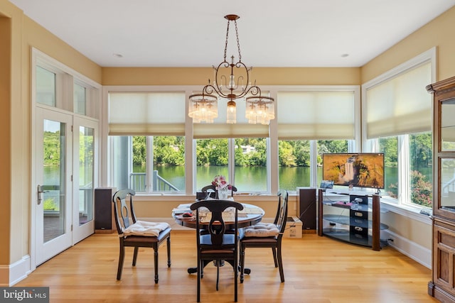 dining area featuring light hardwood / wood-style floors, a chandelier, and french doors