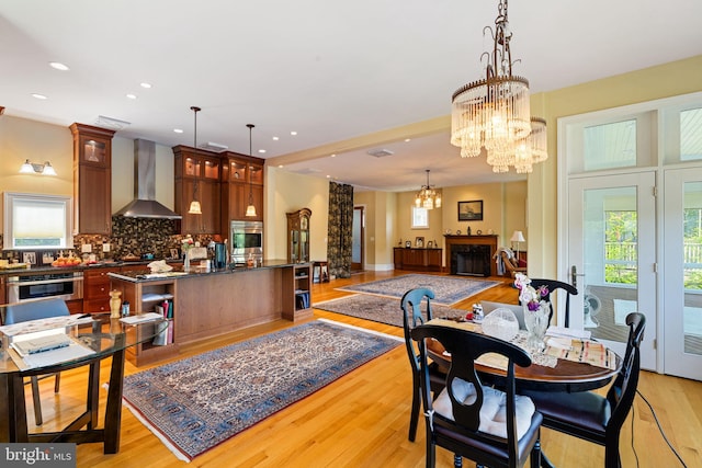 dining space with an inviting chandelier and light hardwood / wood-style floors