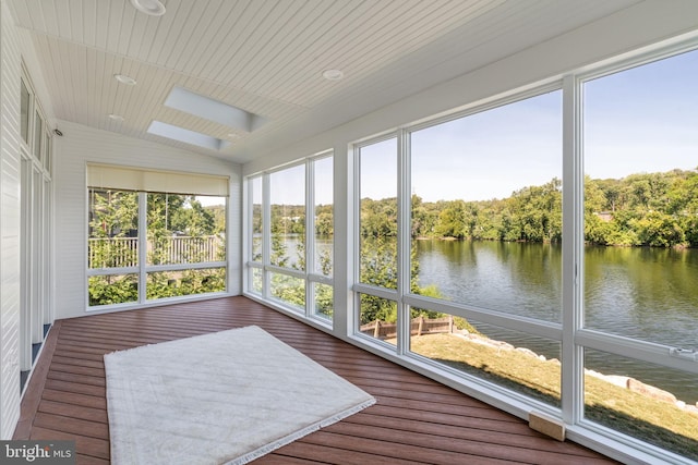 unfurnished sunroom with a water view and vaulted ceiling