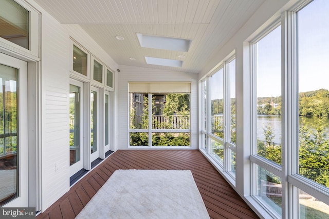 sunroom featuring a water view and vaulted ceiling