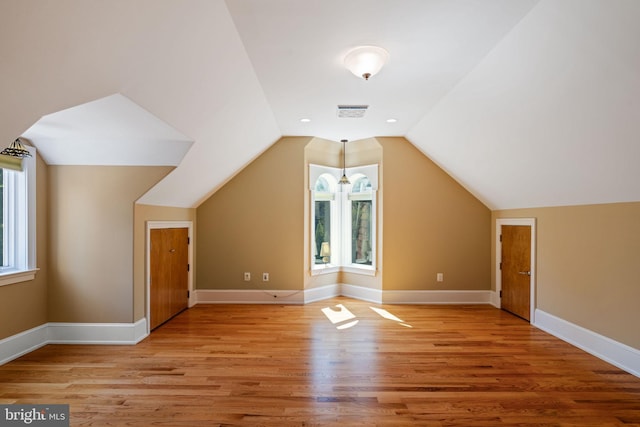 additional living space featuring lofted ceiling and light wood-type flooring