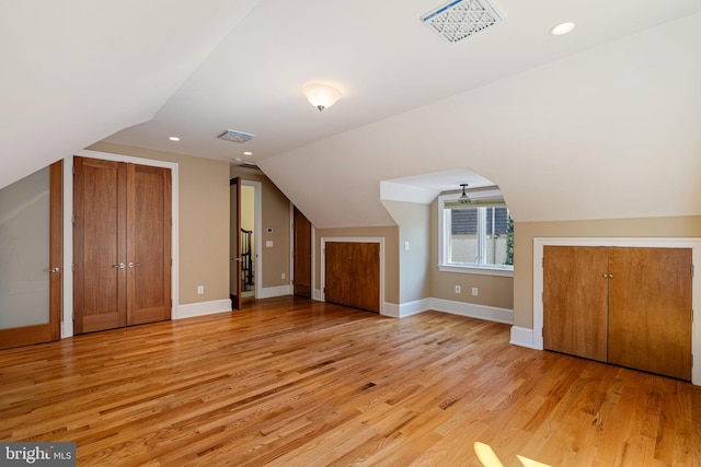 additional living space featuring light hardwood / wood-style floors and vaulted ceiling