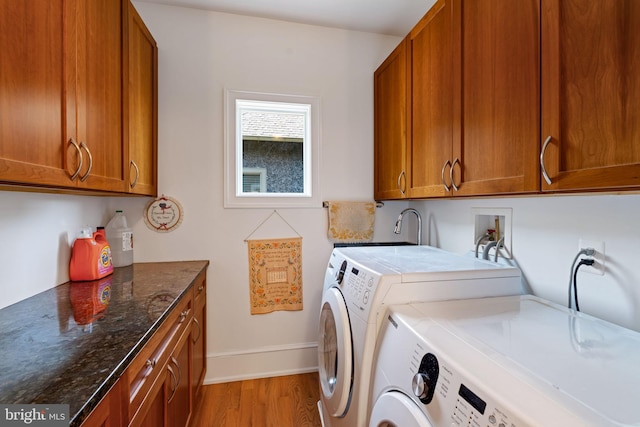 laundry area featuring cabinets, separate washer and dryer, sink, and light hardwood / wood-style floors