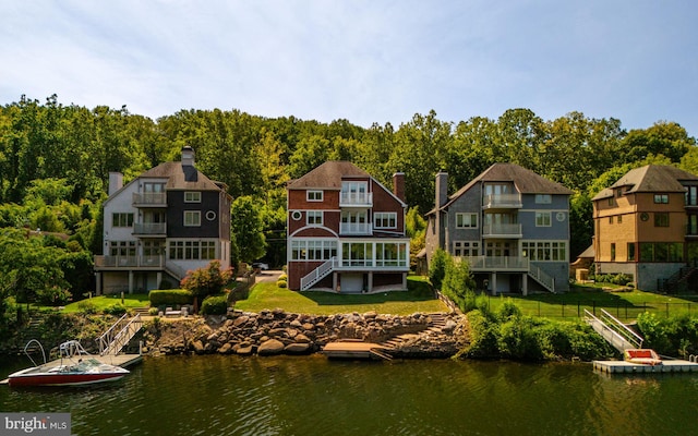 rear view of house featuring a balcony and a water view