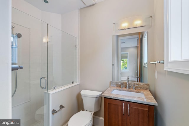 bathroom featuring toilet, a shower with door, and vanity