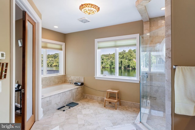 bathroom featuring shower with separate bathtub