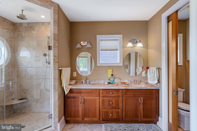 bathroom featuring toilet, a shower with door, and vanity