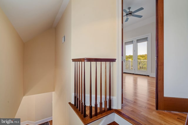 corridor with light hardwood / wood-style floors and vaulted ceiling