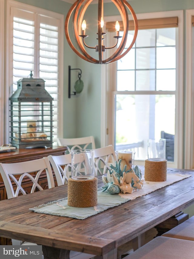 dining area featuring a wealth of natural light and a notable chandelier