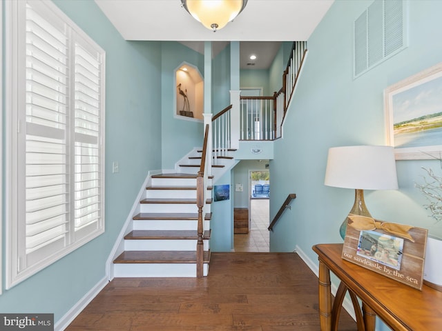 stairs featuring hardwood / wood-style floors and plenty of natural light